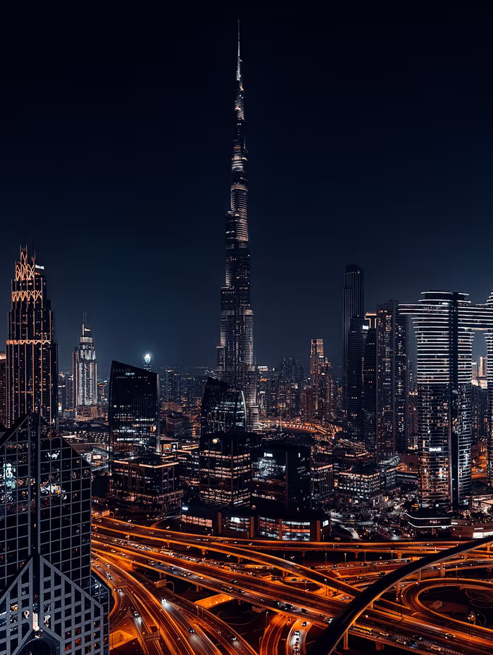 Burj Khalifa at night above Dubai's lit highway interchange