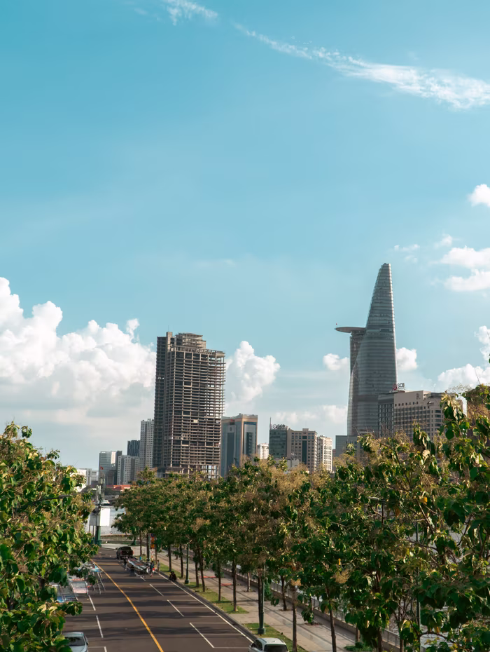 Saigon's skyline above a tree-lined boulevard